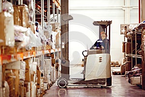 Man on lift operator in uniform at warehouse