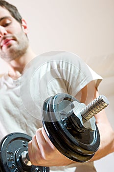 Man lifting dumbbell at home