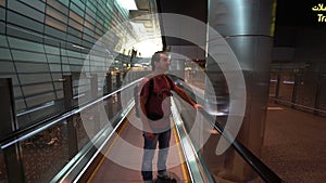 Man lifting on escalator at airport terminal, passenger looking around excited, travel concept, inspirational people