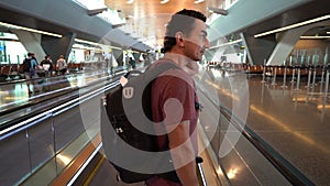 man lifting on escalator at airport terminal, passenger looking around excited, travel concept, inspirational people