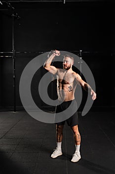 Man lifting a weight with hand, one arm dumbbell snatch, bare chest. Routine workout for physical and mental health.