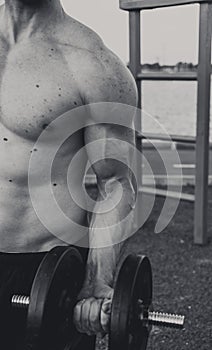 Man lifting weight outdoor black and white photo