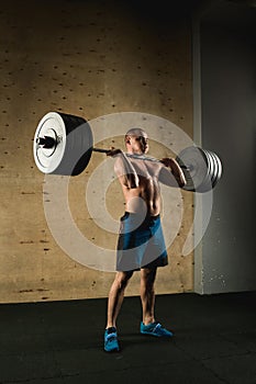 Man lifting weights. muscular man workout in gym doing exercises with barbell