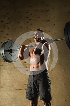 Man lifting weights. muscular man workout in gym doing exercises with barbell