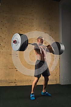 Man lifting weights. muscular man workout in gym doing exercises with barbell