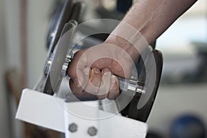 Man lifts dumbbell weight from rack in gym