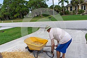 Man lifts wheelbarrow full of gravel