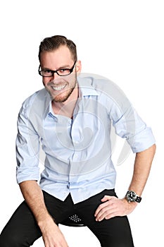 Man in light blue shirt and jeans sitting down