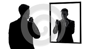 Man lighting cigarette, conscience voice asking quit smoking, mirror reflection