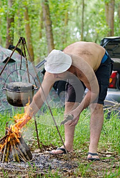 Man lighting a cooking fire while camping