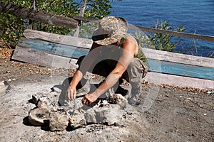 A man lighting a fire on a camping trip
