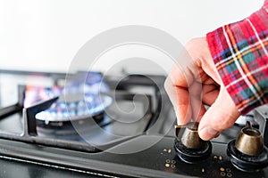 A man lighting the gas-stove with by means of automatic electric ignition. Modern gas burner and hob on a kitchen range