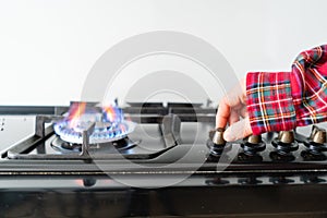 A man lighting the gas-stove with by means of automatic electric ignition. Modern gas burner and hob on a kitchen range