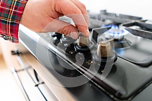 A man lighting the gas-stove with by means of automatic electric ignition. Modern gas burner and hob on a kitchen range