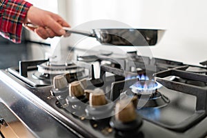 A man lighting the gas-stove with by means of automatic electric ignition. Modern gas burner and hob on a kitchen range