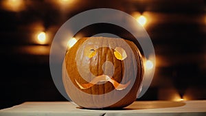 Man lights a candle inside a Halloween pumpkin with a match in dark room.