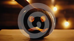 Man lights a candle inside a Halloween pumpkin with a match. in dark room.