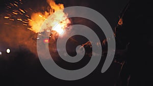 A man lights pyrotechnics on the beach at night