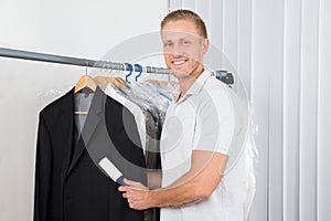 Man with lint roller in clothes store