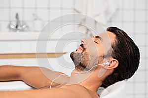 Man listening music in earphones in