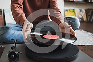 Man listening music, relaxing, enjoying life at home. Turntable playing vinyl LP record.