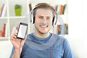 Man listening music showing blank smart phone screen