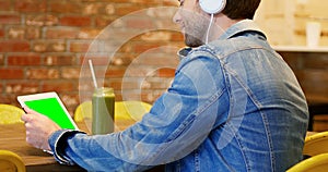 Man listening to music on digital tablet