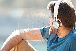 Man listening to music with headphones contemplating