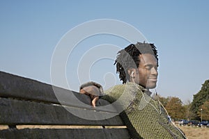 Man Listening To Music While Sitting On Park Bench