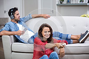 Man listening to music while woman changing channel