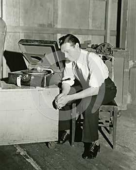 Man listening to portable gramophone