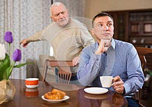 Man listening to reprimanding from aged father