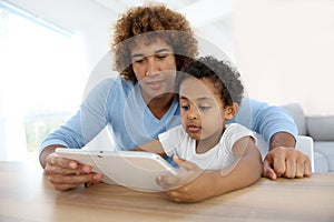 Man with little boy using tablet