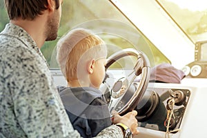 Man with little son driving boat