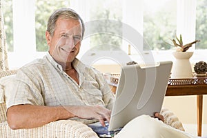 Man in living room with laptop smiling