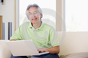 Man in living room with laptop smiling