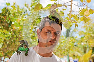 Man with lizards on head and shoulder.