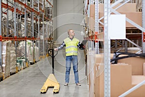 Man with loader and clipboard at warehouse