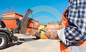 Man loading of construction debris container on truck