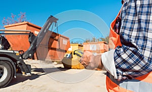 Man loading of construction debris container on truck photo