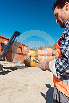 Man loading of construction debris container on truck