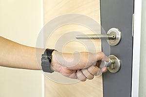 Man locking a door knob and stainless steel door handles on a wood door