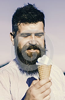 Man with long beard enjoy ice cream. Sweet tooth concept. Bearded man with ice cream cone. Man with beard and mustache
