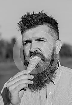 Man with long beard enjoy ice cream. Sweet tooth concept. Bearded man with ice cream cone. Man with beard and mustache