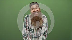 Man with long beard leans forward and smiles in studio; amusement playfulness curiosity quirkiness