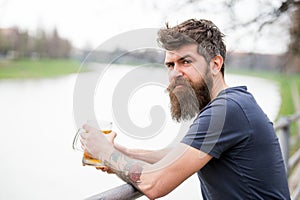 Man with long beard looks relaxed. Man with beard and mustache on calm face, river background, defocused. Bearded man