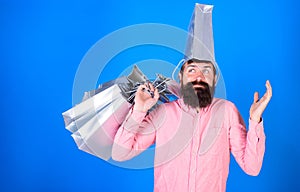 Man with long beard and silver bag on head having fun. Hipster with stylish beard doing shopping, fashion and sales