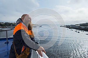 Man with long beard smiles, and looks to the sky