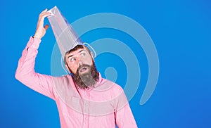 Man with long beard wearing silver paper bag on his head, madness concept. Shopaholic undergoing