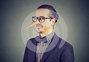 Man with long nose isolated on gray background. Liar concept. photo
